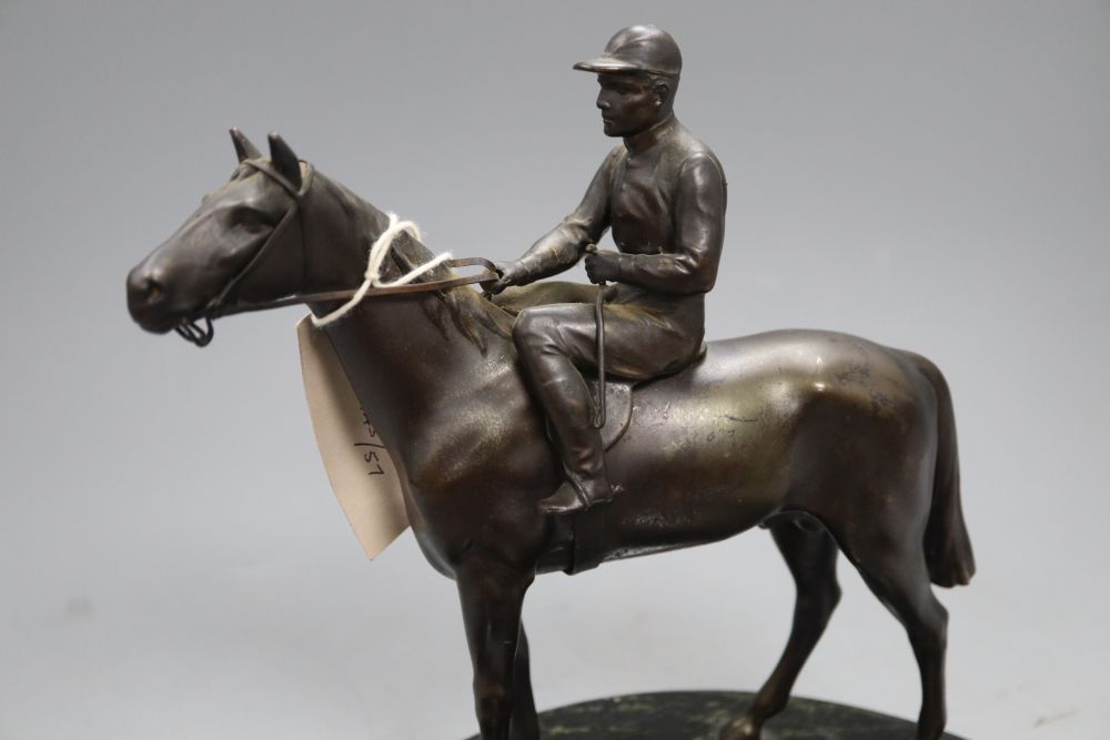 A spelter model of a horse and jockey, surmounted on a serpentine ashtray, height 23cm